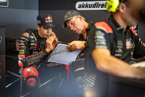Das Bild zeigt den IntactGP Moto3-Fahrer Guido Pini beim Gespräch mit seinem Crewchief.